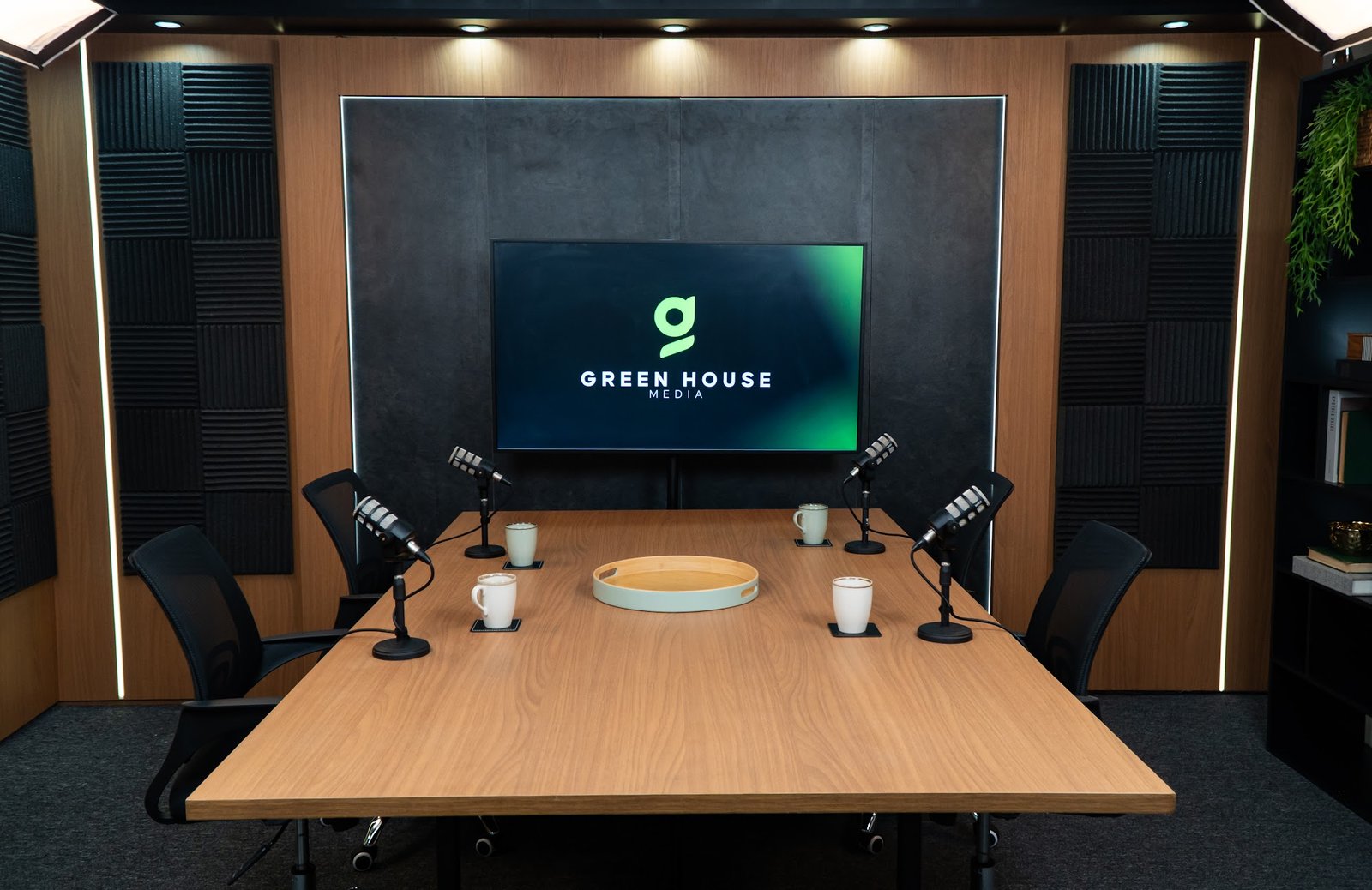 Mesa de gravação com quatro microfones e TV